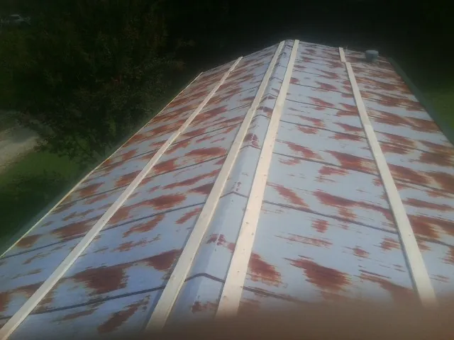 Rusted metal roof panels with new wood purlins before replacement — Storm Damage Roof Repair in Bejou by Roofing Brothers