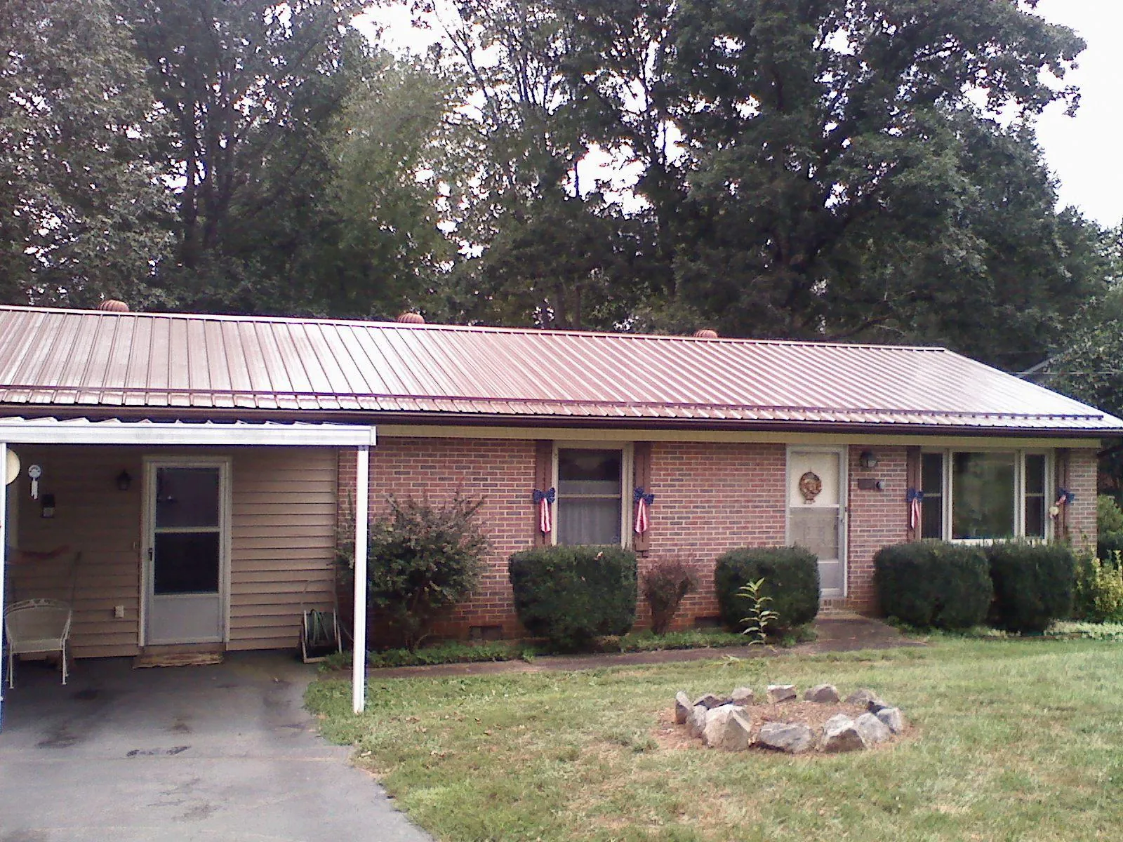Bronze metal roof and carport on a brick ranch home — Roof Repair work by our crew in Bejou