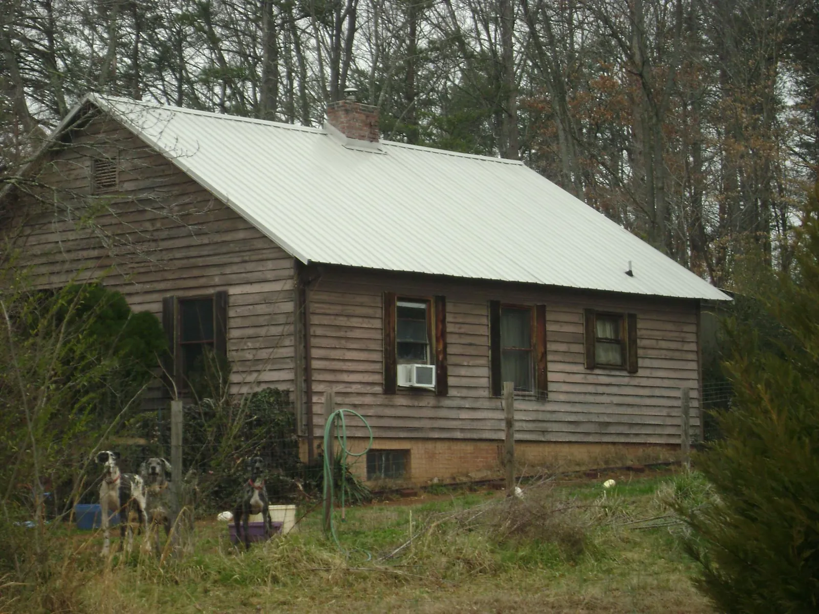 White metal roof on an old wood sided farmhouse, from a Metal Roof Installation job in Bejou